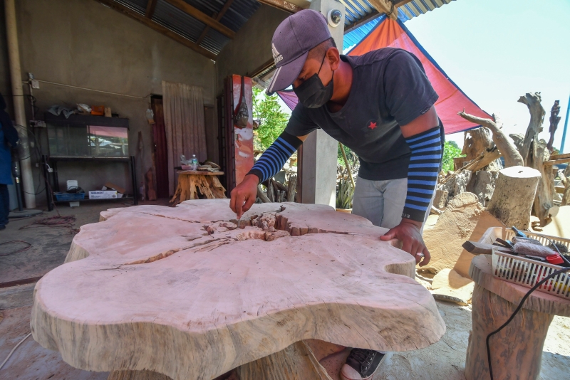 莫哈末哈菲兹正在完成顾客特别订制的木桌。
