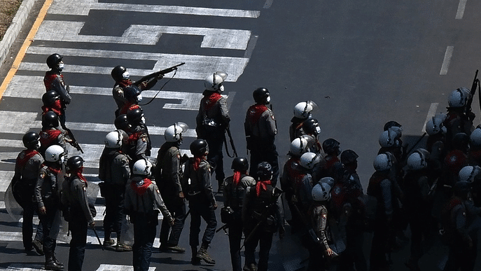 Police, with some holding up firearms, stand by a sign on a road that reads Police, with some holding up firearms, stand by a sign on a road that reads