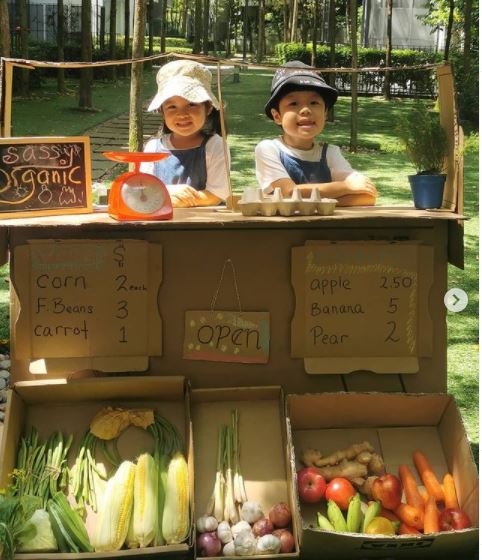 马珮芝透过有机农贸市场的主题式学习，使陈柔希（左起）及陈宥仁从中学习沟通、数学及蔬果的营养价值等。