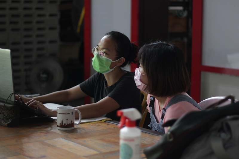 刘佩鑫（左）作为策展人，与参展艺术家之一的冼佩珊（右）密切讨论布展的详情。（摄影：Amirul Rahman）