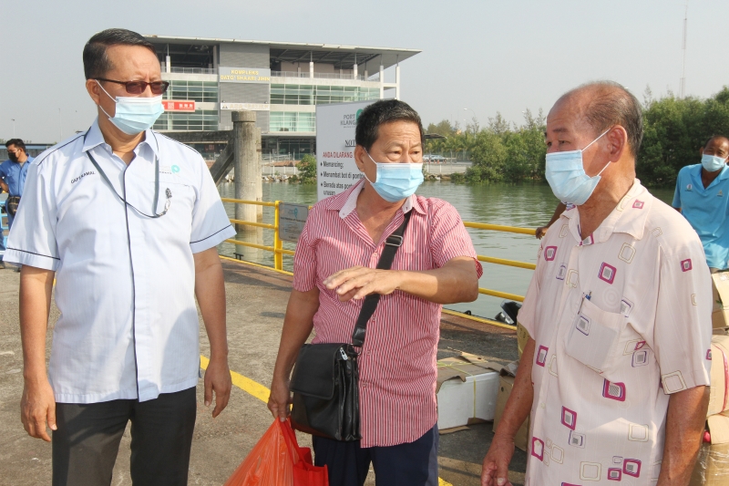 卡玛（左起）在巡视码头设施时，刚巧遇上搭船的五条港渔村管委会主席陈水清。右黄清吉。