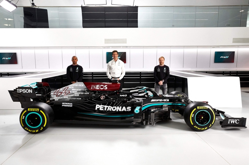 马赛地车队发布2021年新战车W12，车队领队沃尔夫（中）与两位车手汉密尔顿（左）和博搭斯与依然沿用上赛季黑色车身涂装的新战车合影。（法新社照片）