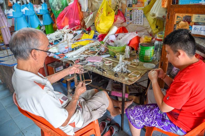 潘顺财的父亲潘国兴（左），虽然年逾80岁，但每日都会到店里工作。