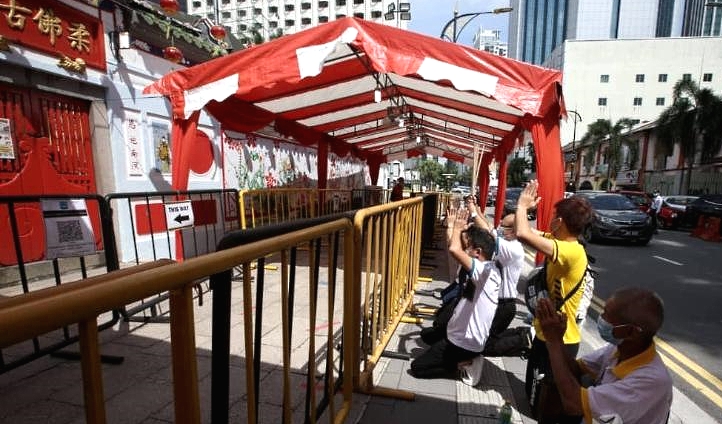 Some devotees are seen praying outside the temple. SIN CHEW DAILY