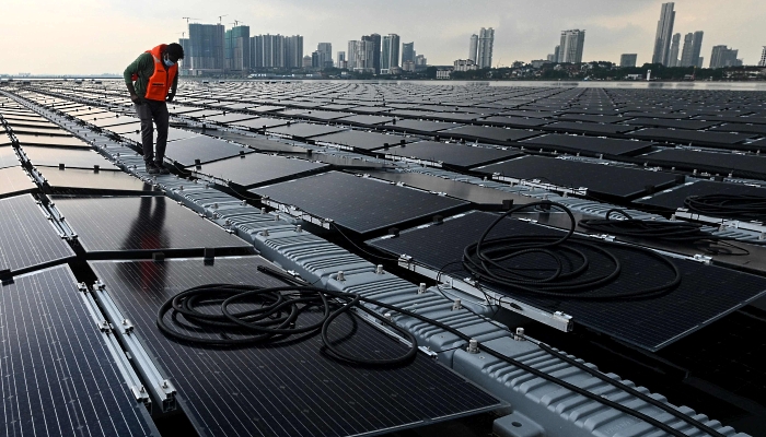 A worker checking cables on a floating solar power farm off Singapore's northern coast just across the Malaysian state of Johor. AFP