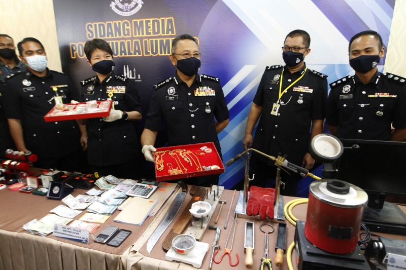 赛夫（右三）、隆市副总警长拿督杨丽珠（左三）及建功警察在新闻发布会上展示起获的金饰、现款和熔金仪器等等。