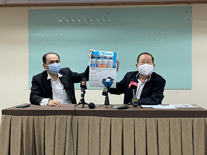 张天赐（右）展示网售疫苗的截图，促请民众勿信以为真。旁为马华公共服务及投诉部法律顾问余家福。