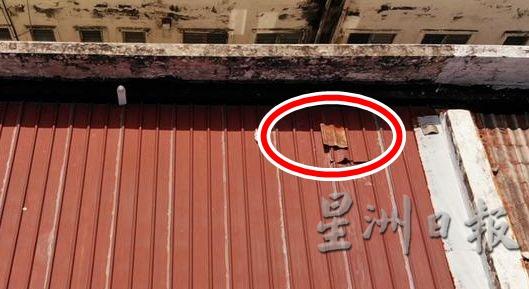 张民生使航拍器到华堂顶楼拍摄，发现位于茶水间的工业锌板屋顶（圆圈处）被剪破。