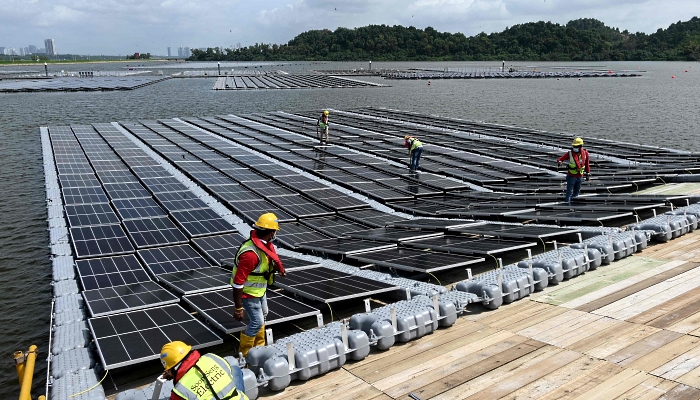Workers assembling solar panels at Tengeh Reservoir in Singapore. AFP