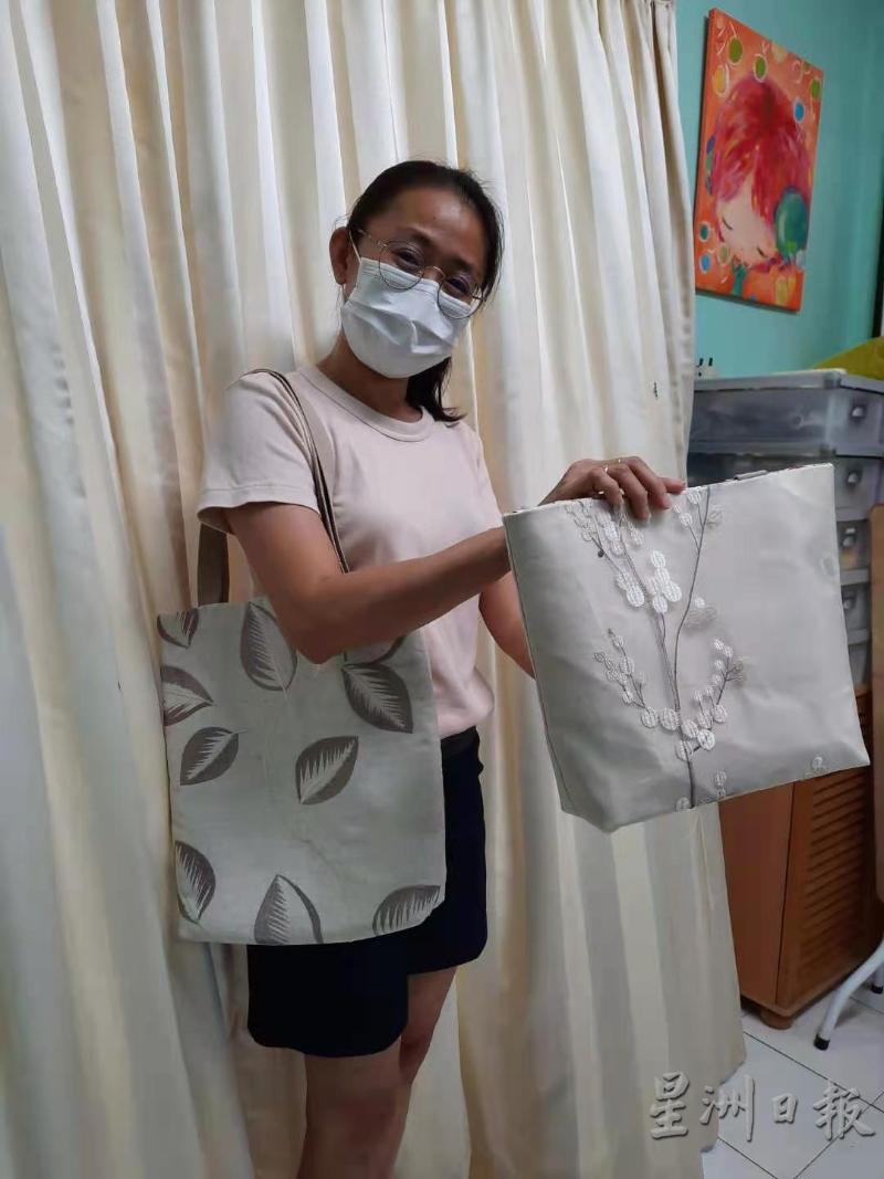 邱晓晶使用学生捐献的窗帘样品，制作布包。