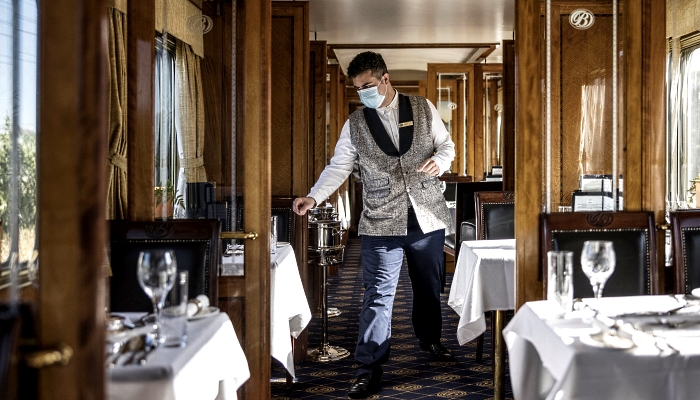 Blue Train waiter Nelson checks the last details of the tables ahead of the dinner service in the dining car. AFP