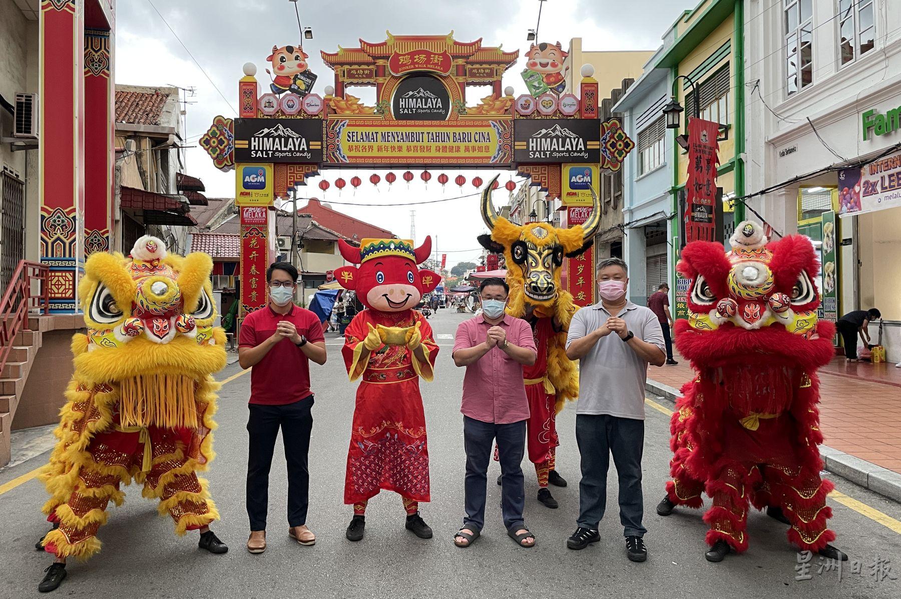 在舞狮、金牛和吉祥物的祝福下，陈炜建（左起）、颜天禄和蔡永泉希望鸡场街夜市取得“开门红”。