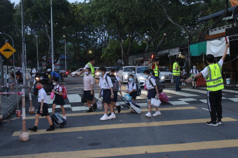 家教协会爱心交通组在校外指挥交通，确保学生安全。（图：星洲日报）