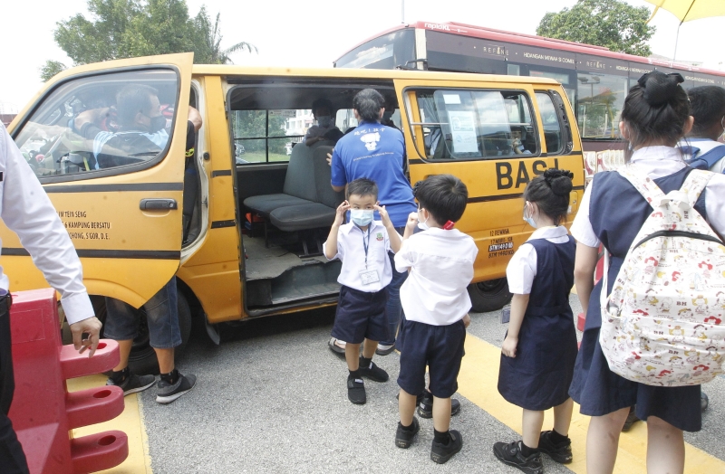 校巴和校车业者配合校方的安排，让学生们排队上车。（图：星洲日报）

