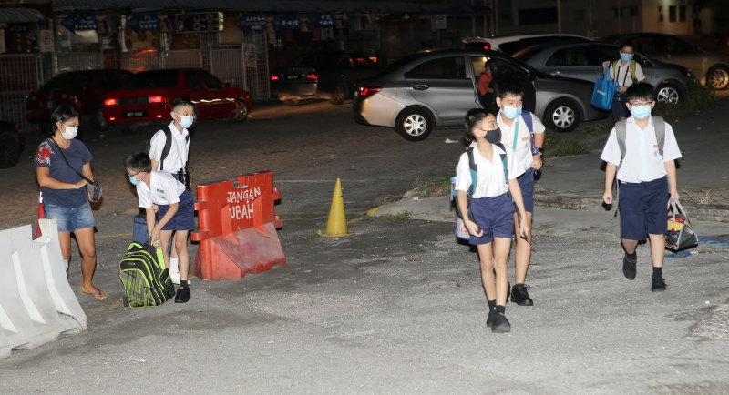 学生们陆续抵达学校后，与同学结伴步入校园。（图：星洲日报）