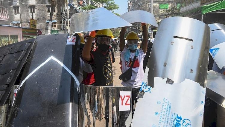 Protesters stand behind shields during a demonstration against the military coup in Yangon. AFP Protesters stand behind shields during a demonstration against the military coup in Yangon. AFP