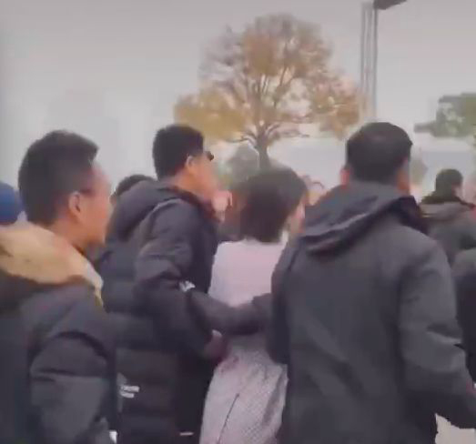 工作人员直接揽着刘涛，不停示意围观群众让道，一边不停大吼“让开”，语气非常凶狠。