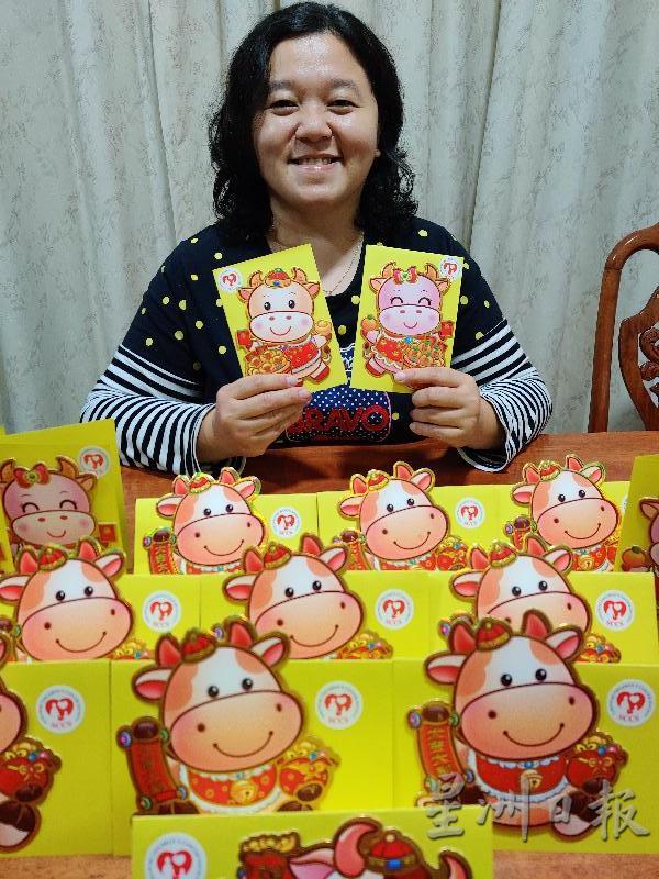 砂儿童癌症协会副经理刘凯欣展示派给癌童的新年红包。