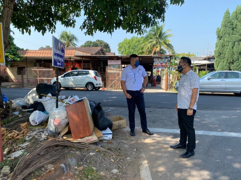 洪建华（右）和官员亲自到场巡视昂古路垃圾堆的情况。