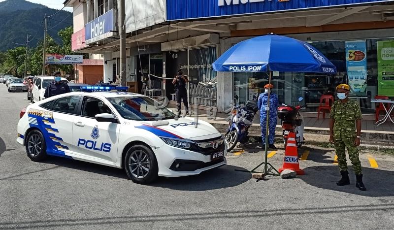 警方巡逻车在昆仑喇叭巴刹外头停下，透过广播呼吁人们严格遵守SOP。