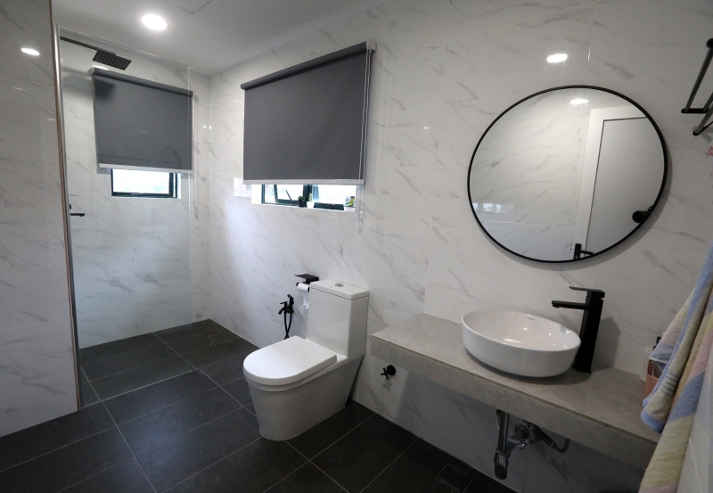 后：经过翻新后的主人房浴室，显得宽敞，采用白色大理石纹地砖，配搭黑色粉末涂层的五金配件。