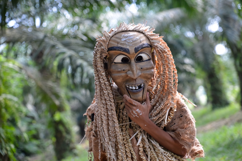 玛美丽族原住民在油棕种植园中戴上自制传统面罩。图库图

