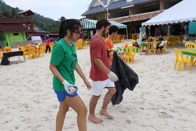 志愿者们在海边清理垃圾，打造一个干净的海边。
