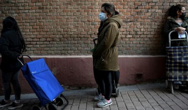 Mother-of-two Reina Chambi waiting outside a soup kitchen in the freezing wind in the Vallecas district. AFP
