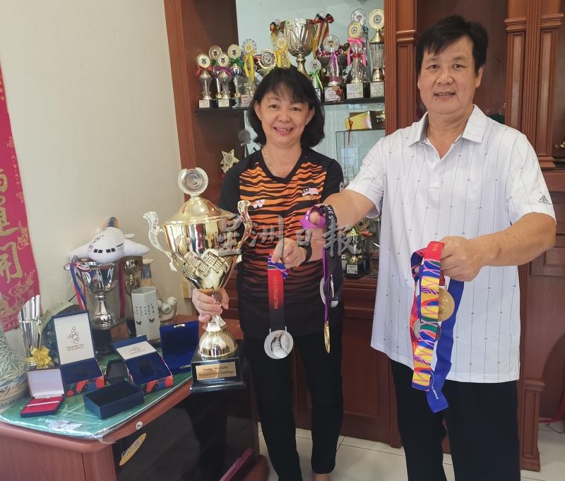 李志兴和廖雪萍展示儿子李梓嘉过去在球场上赢得的奖牌。