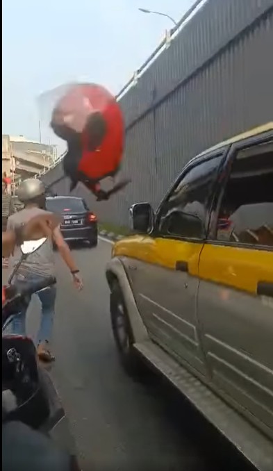 摩托车骑士猛掷头盔砸破四驱车的车窗。 摩托车骑士猛掷头盔砸破四驱车的车窗。