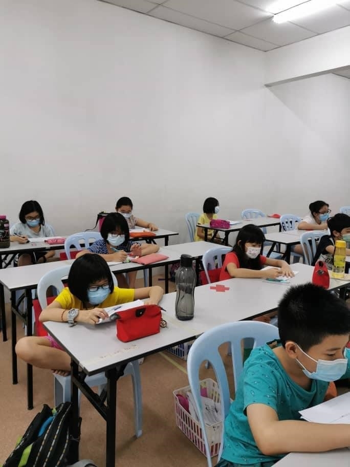 疫情之下，学生们必须在新常态下，佩戴口罩上补习课。