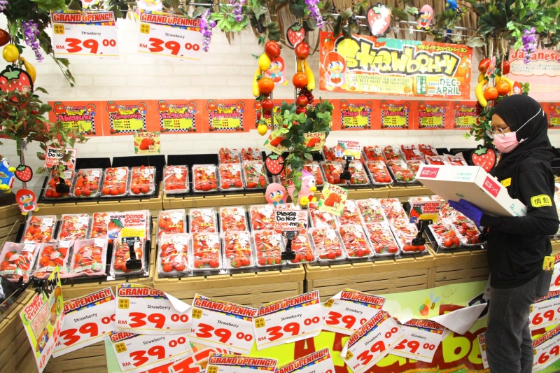 Don Don Donki水果区出售当季的水果，图为工作人员摆放当季水果——草莓。
