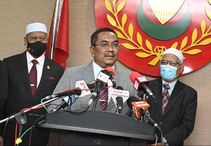 沙努西（中）在行政议员旺罗马尼（左）及莫哈末哈耶迪等人陪同下，宣布吉州政府将颁发奖励给李梓嘉。