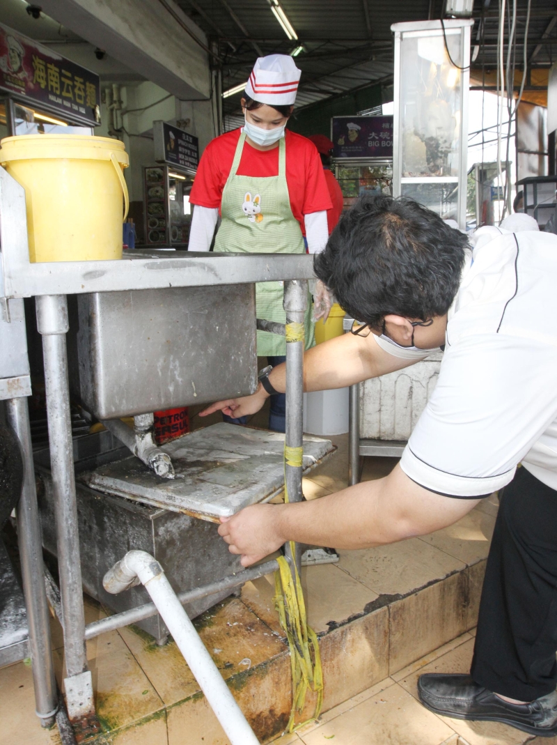 卫生小组官员检查各食肆店的滤油器是否发挥用途。