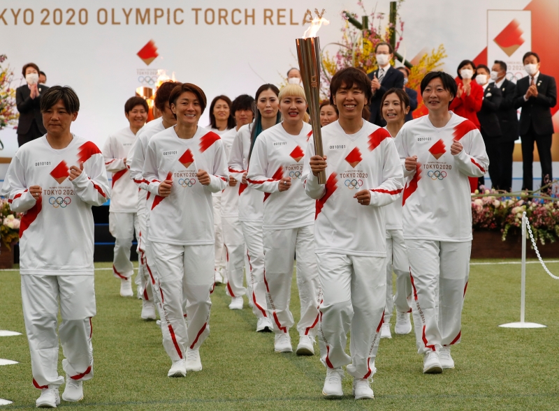 火炬接力的第一棒是日本在2011年获得女足世界杯冠军时的主力队员，岩清水梓手持火炬与另外14名球员以及主教练佐佐木一起跑出球场。（欧新社照片）