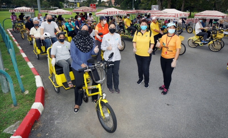 诺丽（前排左一）也踏起一辆黄包车，载一名视障者。左二起是霹雳旅游局首席执行员努玛丽斯、林秀玲、冯盈仪。