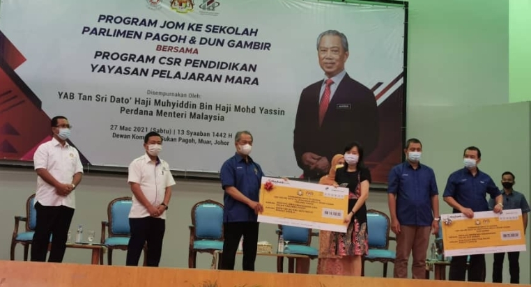 慕尤丁（左三）移交模拟支票给巴莪国会选区内的学校代表。

