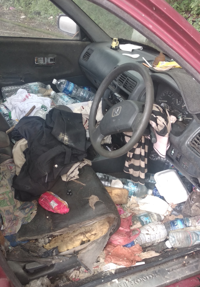 车内堆满各种垃圾和腐蚀的物品。