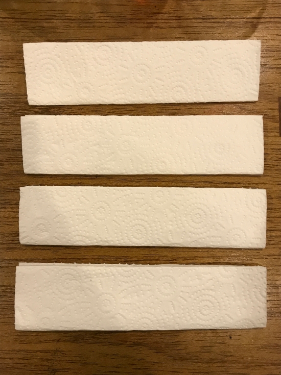 02. 将厨房纸巾折成1吋左右宽度，再对折成“V”形。 重复这个步骤，完成4片相同形状的纸巾。