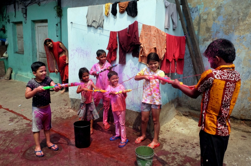 儿童们在印度加尔各答用装满颜色的水枪互相喷洒，庆祝洒红节。

