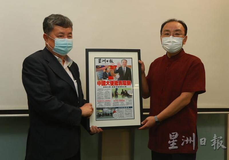 翁昌文（左）赠送珍藏版的《星洲日报》封面报道给欧阳玉靖，是他在2020年12月20日抵达吉隆坡，出任第16任中国驻马大使的新闻报道，有珍贵的收藏价值。