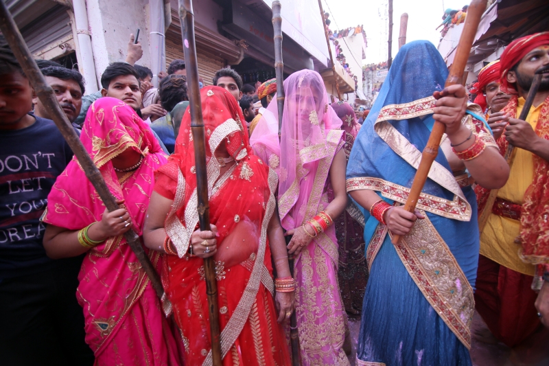 印度北方邦的伯尔萨纳举行洒红节「棒打男人」的传统节庆活动上，身著鲜艳服装的妇女手持木棒击打男人。　

