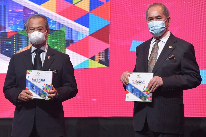 慕尤丁（左）在旺朱乃迪陪同下，为2021至025年合作社转型计划（TransKoM）主持推介礼，