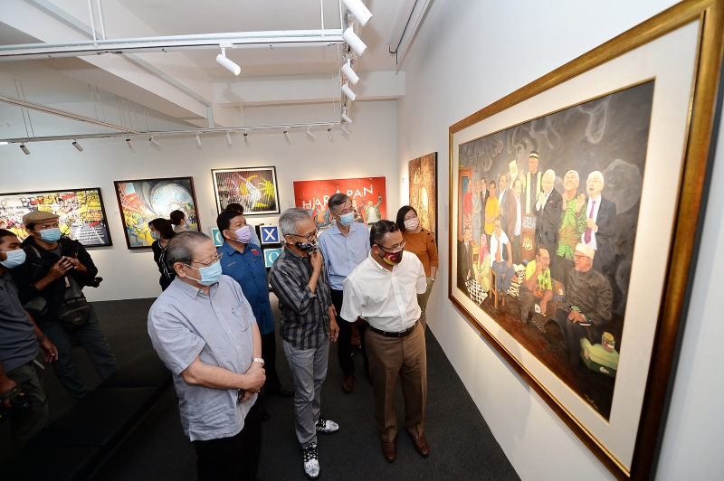 林吉祥（前排左起）及潘俭伟为阿米鲁丁讲解由潘俭伟所创作、题为《喜来登行动》的油画。