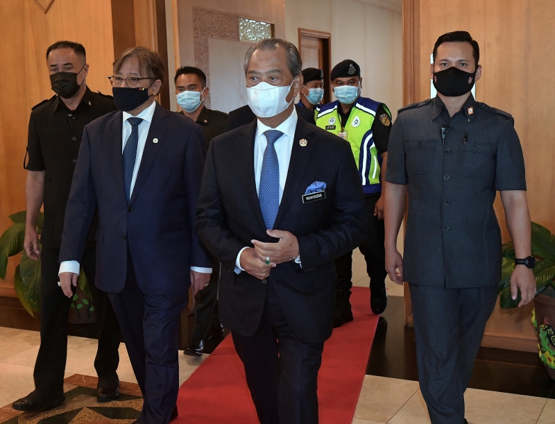 首相慕尤丁（中）抵达古晋国际机场，他会在古晋进行2天工作访问；左为到机场迎接他的砂首长阿邦佐哈里。（马新社图）