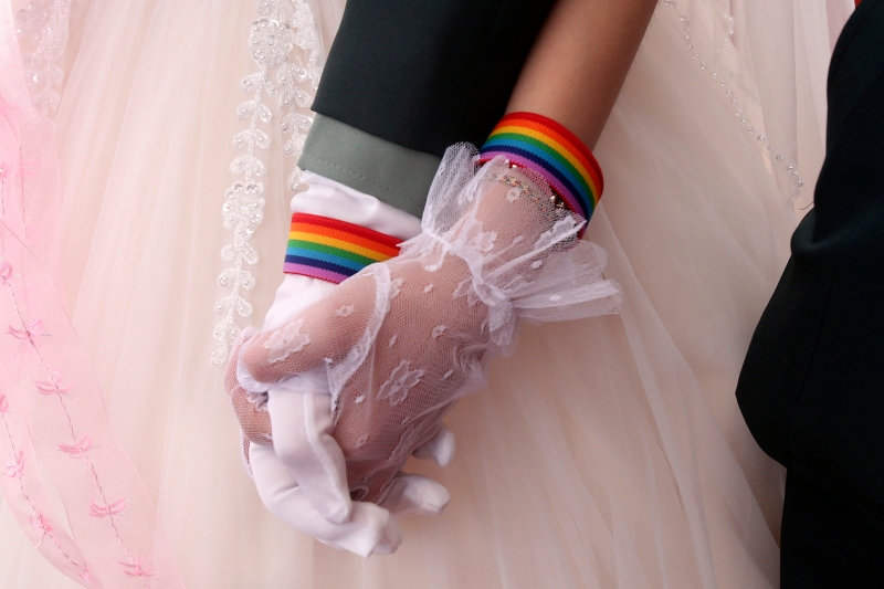 台湾是亚洲第一个，也是目前唯一承认同性婚姻合法的地区。图中一对同性情侣在婚礼上十指紧握。(图片 美联社)