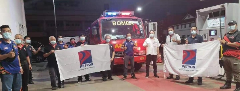 林胜鸿（中）和队员们感谢陈文强（右四）赞助汽油给该消防队。