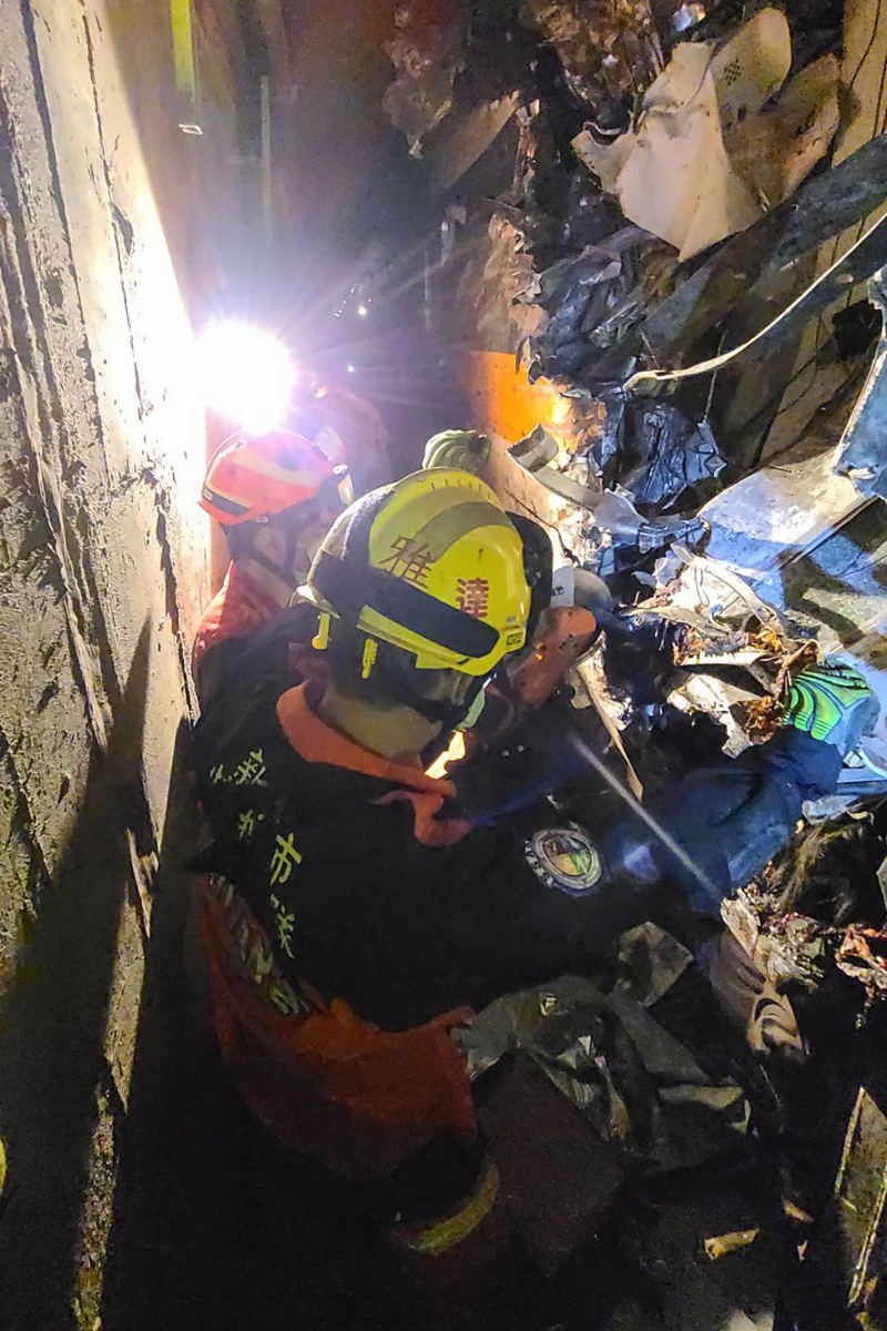 消防人员仔细翻查，试图从凌乱不堪的残骸中寻找死伤者的踪迹。（法新社照片）