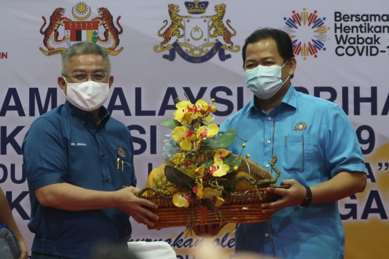纳兹里阿里（右）赠送纪念品予卫生部部长阿汉峇峇。