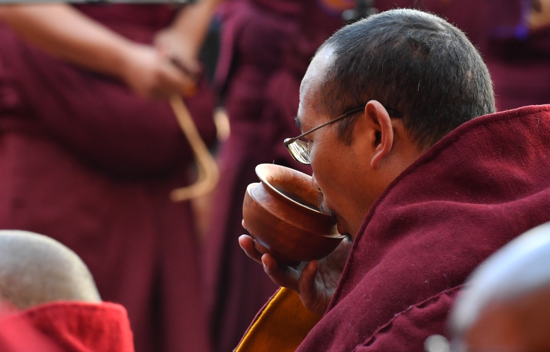 一名出席格西拉让巴学位授予仪式上的僧人喝斋茶。